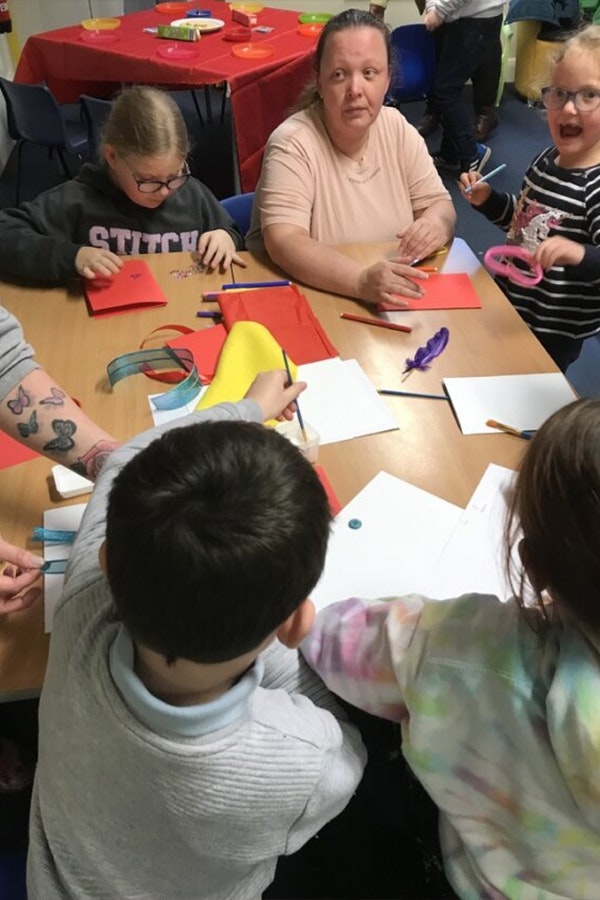 Parent with children in paper craft workshop